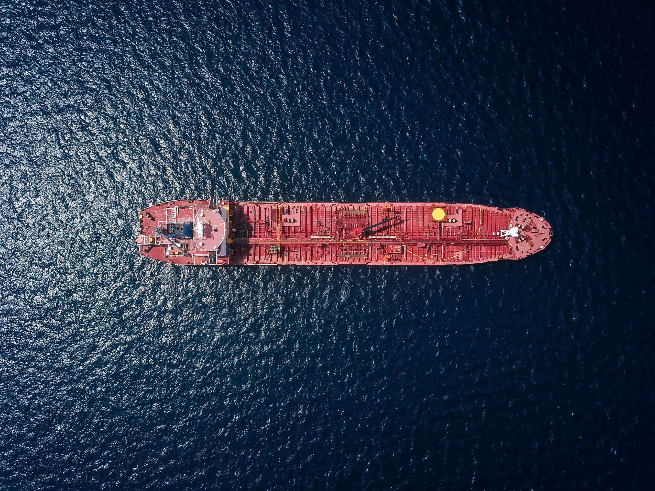 海に浮かぶ大きく赤い貨物船